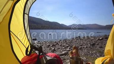 阿尔泰。 野营的女人躺在帐篷里，穿着徒步旅行靴，在度假时放松。 两个视频